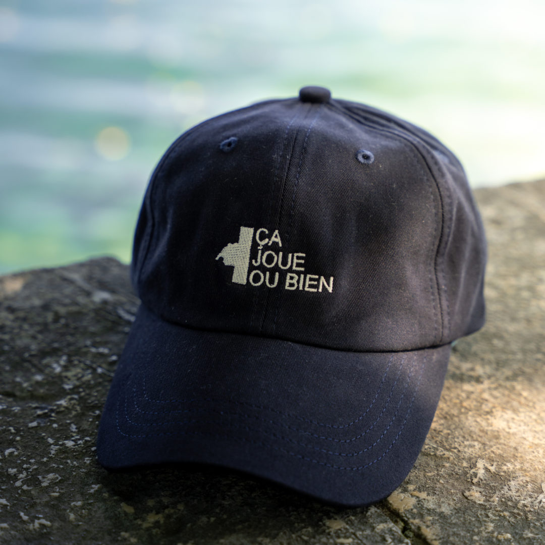 Une casquette çajoueoubien foncé avec le logo à l'avant.- de face