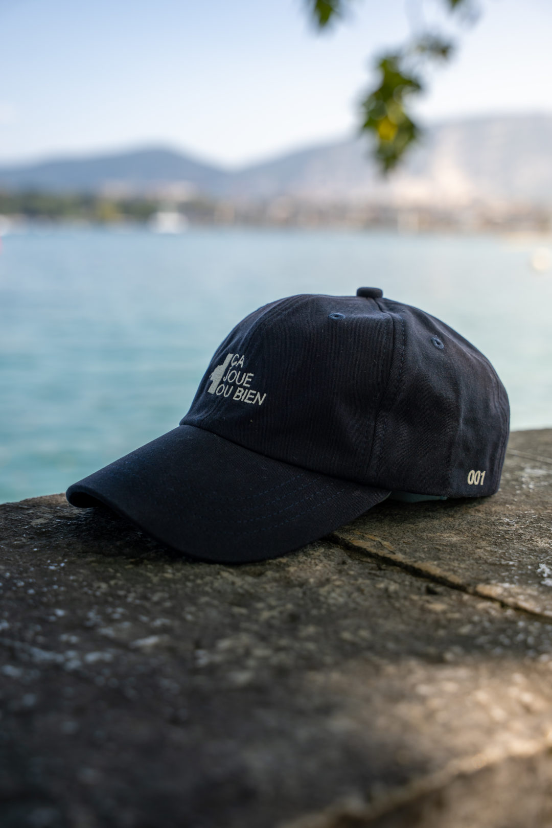 Une casquette çajoueoubien foncé avec le logo à l'avant.- coté